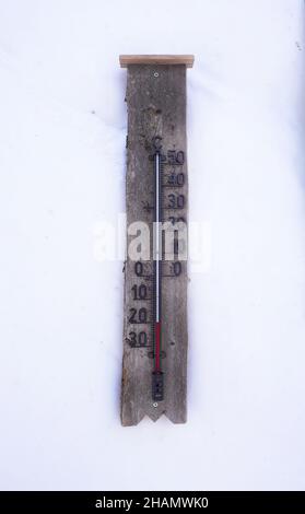 Un termometro in legno su una parete di neve che mostra meno 20 gradi Celsius al di sotto dello zero cerchio artico lapponia Foto Stock