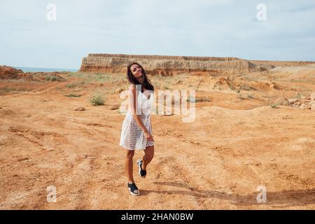 bella donna che cammina nel deserto di argilla Foto Stock