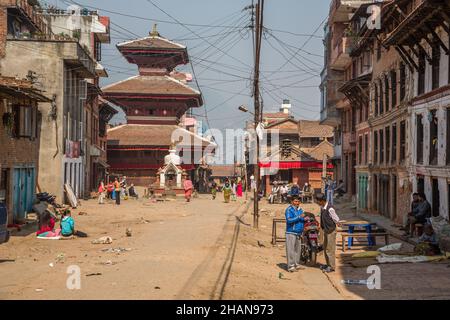 Scena di strada con un tempio indù nel villaggio medievale di Newar di Khokana nella valle di Kathmandu del Nepal. Foto Stock