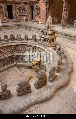 Il Tusha Hiti o Royal Bath nel Sundari Chowk nel vecchio palazzo reale in Piazza Durbar, Patan, Nepal. Alla testa del bagno c'è un modello in pietra o Foto Stock