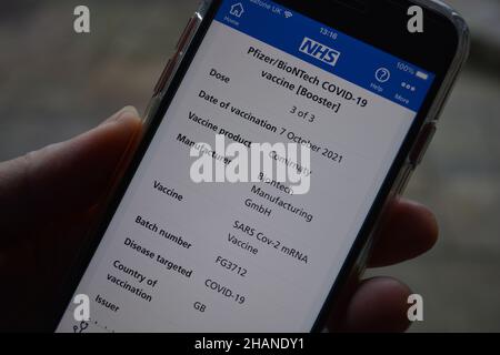 App NHS aperta su smartphone, con vaccino Pfizer BioNTech Covid-19, dose Booster ricevuta Foto Stock