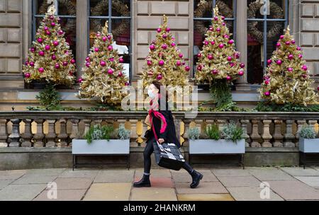 Edimburgo, Scozia, Regno Unito. 14th dicembre 2021. Vedute generali dei negozi e dei bar nel centro di Edimburgo il giorno in cui il primo ministro scozzese ha reso una dichiarazione al Parlamento scozzese sulle restrizioni sociali per controllare l'attuale aumento della variante Omicron nei casi di Covid-19 in Scozia. PIC; i membri del pubblico camminano davanti al bar decorato con alberi di Natale. Iain Masterton/Alamy Live News. Foto Stock