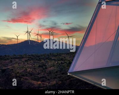 Tramonto su una collina con turbine eoliche Foto Stock