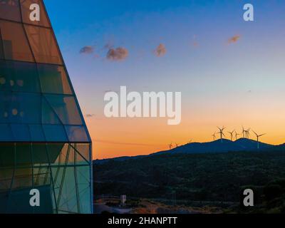 Tramonto su una collina con turbine eoliche Foto Stock