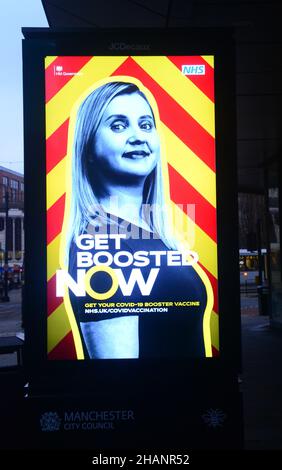 Manchester, Regno Unito, 14th dicembre 2021. Un segnale illuminato commissionato dall'NHS e dal governo del Regno Unito esorta le persone ad ottenere il vaccino di richiamo ora per proteggere contro Covid-19 o Covid o Coronavirus. Il 13th dicembre il centro di vaccinazione del municipio di Manchester, nel Regno Unito, ha dovuto allontanare le persone alla fine di una lunga coda che aveva aspettato sotto la pioggia per oltre 3 ore. Il governo del Regno Unito ha annunciato un programma di vaccinazione di richiamo di massa contro la variante Omicron Covid. Credit: Terry Waller/Alamy Live News Foto Stock
