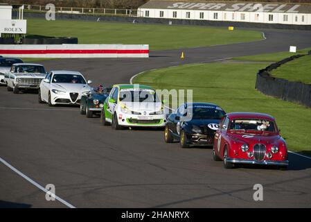 Un marchio Jaguar 2 in rosso testa una linea di auto classiche e sprt tra cui una Ford Puma, Morgan, Ford Falcon e un modello Tesla prima della partenza. Foto Stock