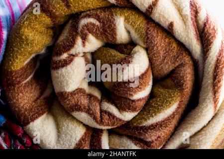 Arrotolato-up, lana polare, marrone fleece coperta background.Close up preso. Foto Stock