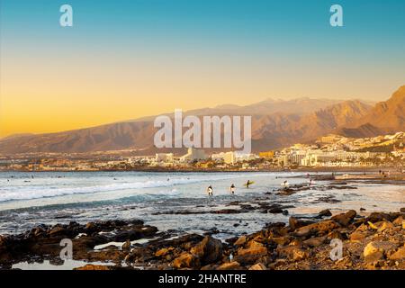 Playa de las Americas. Surfers sulla spiaggia a Tenerife al tramonto Foto Stock