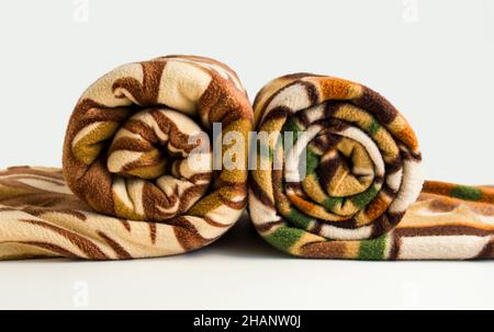 Doppia misura due colore marrone, polare, coperta di pile rotolata sullo sfondo bianco. Foto Stock