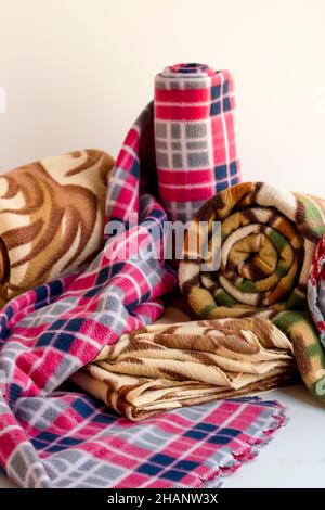 Tre, diverse dimensioni e colore feltro coperta rotolato sullo sfondo bianco dell'immagine verticale Foto Stock