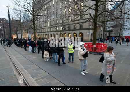 Manchester, Regno Unito, 14th dicembre 2021. I membri del thr pubblico fanno la fila ad un centro di vaccinazione nel centro di Manchester mentre i timori aumentano che la variante di Omicron costringerà il governo a chiudere le parti dell'economia. Credit: Jon Super/Alamy Live News. Foto Stock