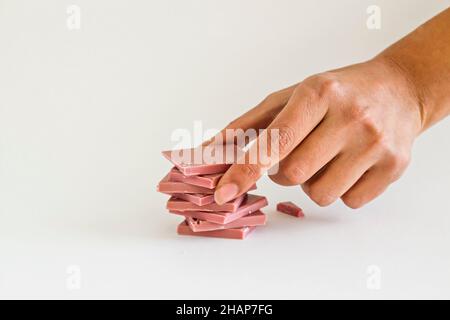 Il quarto tipo di cioccolato: Cioccolato al rubino affettato e impilato a mano su sfondo bianco con spazio copia Foto Stock