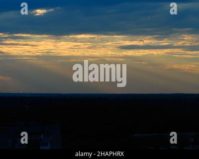 La luce del tramonto si illumina sullo sfondo della periferia della città Foto Stock