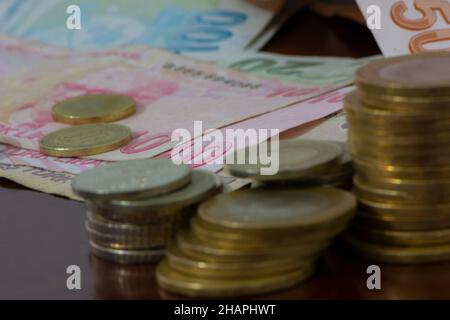 Banconote e monete in lira turche isolate sullo sfondo del tavolo di legno Foto Stock