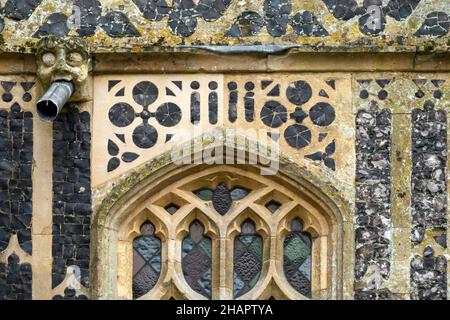 Esempio di intricato vampate di selce su una parete esterna con getto d'acqua gargoyle a St Mary of the Assumption, Ufford, Suffolk Foto Stock