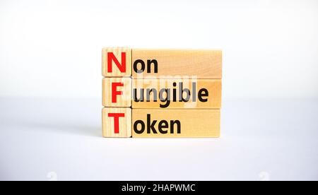 Simbolo token non fungibile NFT. Concetto parole NFT non-fungibile token su blocchi di legno. Bellissimo sfondo bianco, spazio di copia. Business e NFT non-divertimento Foto Stock