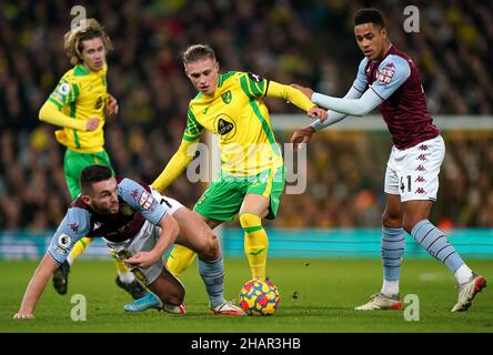 Przemyslaw Placheta (centro) di Norwich City batte per la palla con John McGinn (a sinistra) di Aston Villa e Jacob Ramsey durante la partita della Premier League a Carrow Road, Norwich. Data foto: Martedì 14 dicembre 2021. Foto Stock