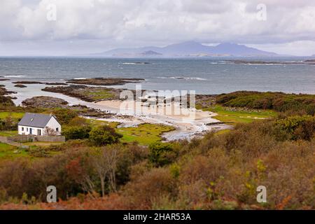 Passeggiate in spiaggia presso la cittadina di Portuairk, l'insediamento più occidentale della terraferma britannica nella Scozia occidentale, con vista sulle piccole isole Foto Stock