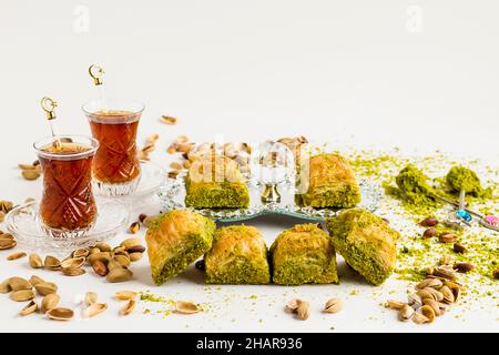 Tradizionale Baklava a secco con dessert turco, sulla superficie bianca con tè turchi, pistacchio e spazio copia Foto Stock