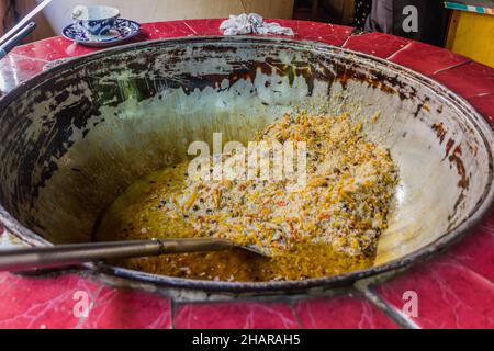 Cucina del plov nel calderone Kazan a Tashkent, Uzbekistan Foto Stock