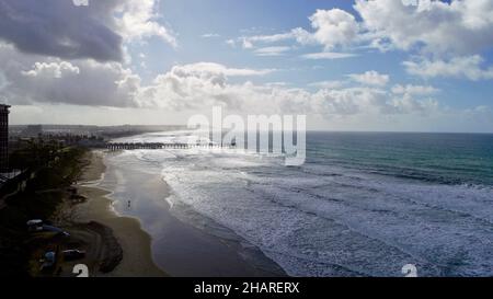 Vista aerea sopra la scogliera su Pacific Beach, sole mattutino che piercing passa le nuvole di pioggia, Crystal Pier in Distance, San Diego, California, USA Foto Stock