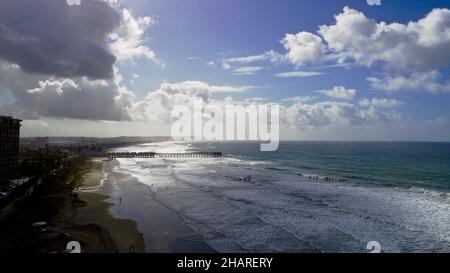 Vista aerea sopra la scogliera su Pacific Beach, sole mattutino che piercing passa le nuvole di pioggia, Crystal Pier in Distance, San Diego, California, USA Foto Stock