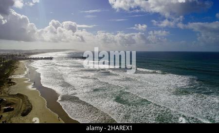 Vista aerea sopra la scogliera su Pacific Beach, sole mattutino che piercing passa le nuvole di pioggia, Crystal Pier in Distance, San Diego, California, USA Foto Stock