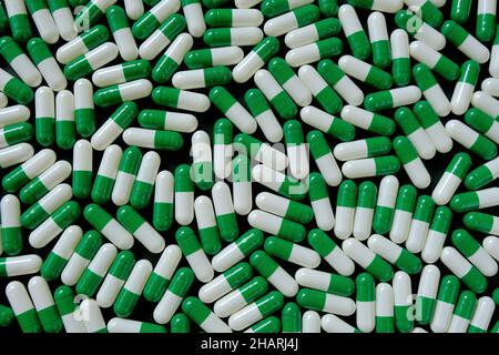 Sfondo verde delle capsule omeopatiche. Medicina alternativa e omeopathy.Vegetable bianco verde capsule.naturali bio erbe preparati Foto Stock