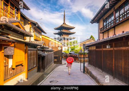 Ragazza giapponese a Yukata con ombrello rosso nella città vecchia di Kyoto, Giappone Foto Stock