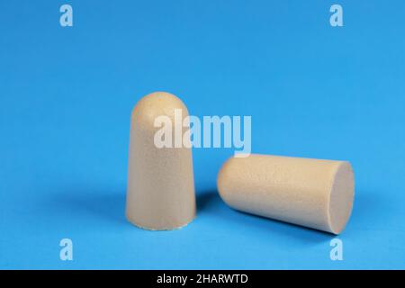 Tappi auricolari in schiuma su sfondo blu. Foto Stock