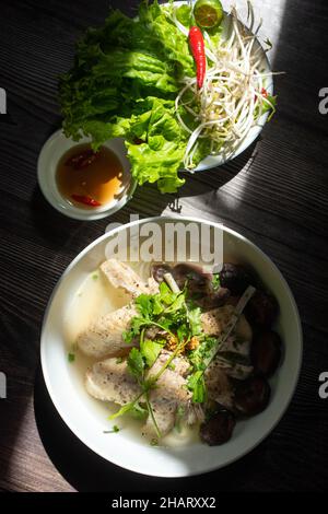 La zuppa di spaghetti ai funghi di pollo è un piatto molto popolare per la colazione in Vietnam. Gli ingredienti includono spaghetti di riso, funghi, pollo, verdure e spi Foto Stock