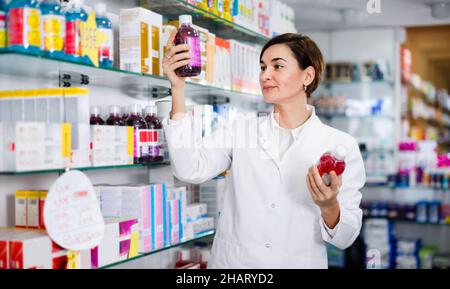 Farmacista femminile che suggerisce prodotti per la cura del corpo utili Foto Stock