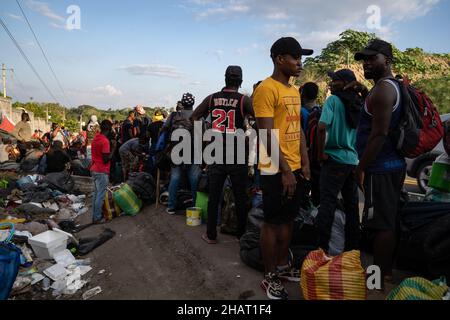 Tapachula, Messico. 14th Dic, 2021. Migliaia di haitiani si allineano e attendono gli autobus forniti dall'Istituto Nazionale Migrazioni Messicano per portarli in altre città del Messico. INM è autobus i migranti per alleviare le sopraffatte autorità migratorie e di asilo nella città di Tapachula, al confine con il Guatemala. Ogni autobus si dirigeva verso una destinazione diversa. I migranti, molti dei quali erano in attesa in linea da più di una settimana, non avevano scelta di destinazione. Molte persone erano ammalate di tosse e di febbre alta. Credit: Diario/Diario Live News Foto Stock