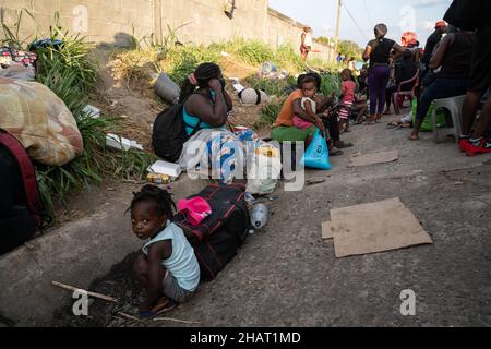 Tapachula, Messico. 14th Dic, 2021. Migliaia di haitiani si allineano e attendono gli autobus forniti dall'Istituto Nazionale Migrazioni Messicano per portarli in altre città del Messico. INM è autobus i migranti per alleviare le sopraffatte autorità migratorie e di asilo nella città di Tapachula, al confine con il Guatemala. Ogni autobus si dirigeva verso una destinazione diversa. I migranti, molti dei quali erano in attesa in linea da più di una settimana, non avevano scelta di destinazione. Molte persone erano ammalate di tosse e di febbre alta. Credit: Diario/Diario Live News Foto Stock