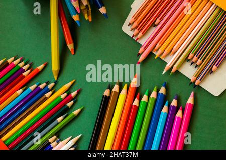 Colorato, vari colori pastelli disegnati su superficie verde, vista dall'alto Foto Stock