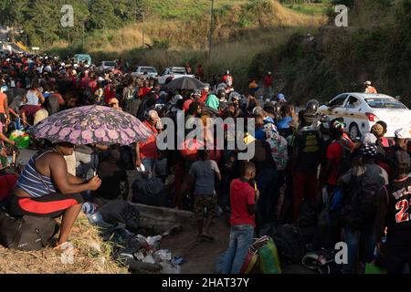 Tapachula, Messico. 14th Dic, 2021. Migliaia di haitiani si allineano e attendono gli autobus forniti dall'Istituto Nazionale Migrazioni Messicano per portarli in altre città del Messico. INM è autobus i migranti per alleviare le sopraffatte autorità migratorie e di asilo nella città di Tapachula, al confine con il Guatemala. Ogni autobus si dirigeva verso una destinazione diversa. I migranti, molti dei quali erano in attesa in linea da più di una settimana, non avevano scelta di destinazione. Molte persone erano ammalate di tosse e di febbre alta. Credit: Diario/Diario Live News Foto Stock