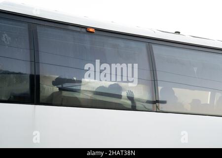 Tapachula, Messico. 14th Dic, 2021. Un migrante ondeggia come l'autobus parte per un'altra città in Messico. INM è autobus i migranti per alleviare le sopraffatte autorità migratorie e di asilo nella città di Tapachula, al confine con il Guatemala. Ogni autobus si dirigeva verso una destinazione diversa. I migranti, molti dei quali erano in attesa in linea da più di una settimana, non avevano scelta di destinazione. Molte persone erano ammalate di tosse e di febbre alta. Credit: Diario/Diario Live News Foto Stock