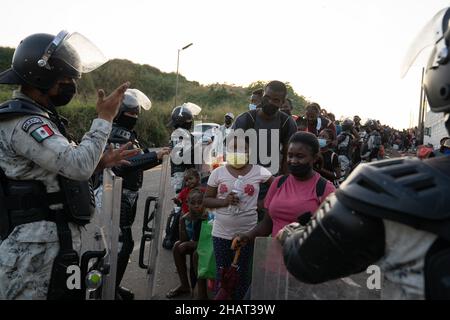 Tapachula (Messico), 14 dicembre 2021, la Guardia Nazionale controlla la folla mentre migliaia di haitiani si allineano e attendono gli autobus forniti dall'Istituto Nazionale Migrazioni Messicano per portarli in altre città del Messico. INM è autobus i migranti per alleviare le sopraffatte autorità migratorie e di asilo nella città di Tapachula, al confine con il Guatemala. Ogni autobus si dirigeva verso una destinazione diversa. I migranti, molti dei quali erano in attesa in linea da più di una settimana, non avevano scelta di destinazione. Molte persone erano ammalate di tosse e di febbre alta. Credit: Lexie Harrison-Cripps Foto Stock