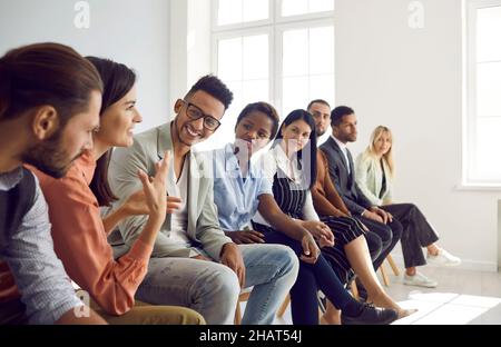 Un gruppo diversificato di giovani felici che hanno discusso durante incontri d'affari o corsi di formazione Foto Stock