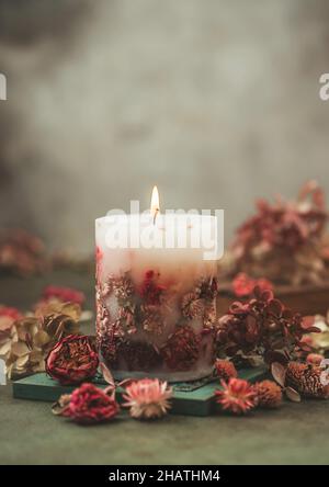 Candele fatte a mano con fiori secchi design unico. Candele profumate decorate con foglie secche e fiori. Messa a fuoco selettiva Foto Stock