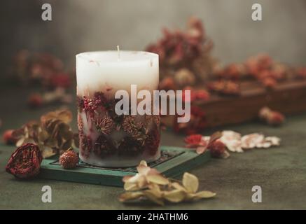 Candele fatte a mano con fiori secchi design unico. Candele profumate decorate con foglie secche e fiori. Messa a fuoco selettiva Foto Stock