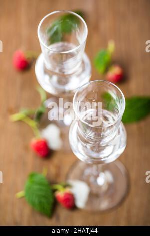 lampone, liquore, rosso, marca, legno, tavola, bevanda, bicchiere, frutta, brandy vetro, bacche, bevanda, alcool, pieno, tipico, Fatti in casa, Spiriuose, vetro sparato Foto Stock