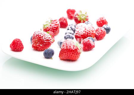 Zucchero in polvere, fragole, lamponi, mirtilli, zucchero, piatto, bianco, sfondo, ombra, riflessione, bianco, isolato, isolato, frutta, frutta, Foto Stock