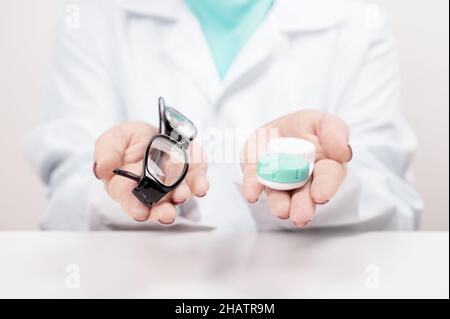 Lenti a contatto o occhiali. Scegliere tra lenti a contatto o occhiali. Medico oculare, oftalmologo offre la scelta di occhiali o lenti a contatto. Miopia Foto Stock