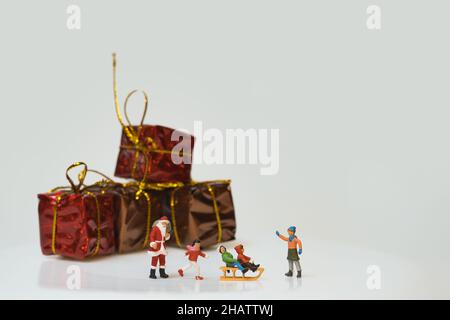 Scena natalizia di figure in miniatura di Babbo Natale e bambini che giocano nella neve Foto Stock