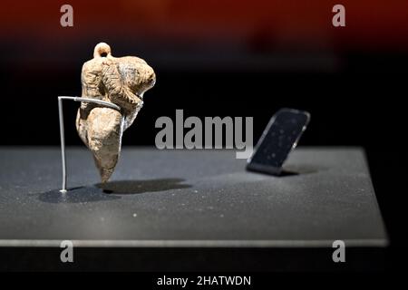 15 dicembre 2021, Baden-Wuerttemberg, Blaubeuren: La più antica rappresentazione figurativa di un essere umano al mondo si trova in una vetrina illuminata. La cosiddetta Venere dei Fel Hohle è alta circa sei centimetri, fatta di avorio di mammut e di circa 40.000 anni. La statuetta di Venere scolpita è stata scoperta nel settembre 2008 durante gli scavi nella grotta carsica di Hohle Fels ai piedi meridionali dell'Albo Svevo vicino a Schelklingen. La statuetta Venere è originaria della cultura del Paleolitico superiore dell'Aurignaciano. Il Museo Preistorico (urmu) nel sito patrimonio mondiale dell'UNESCO sarà Foto Stock