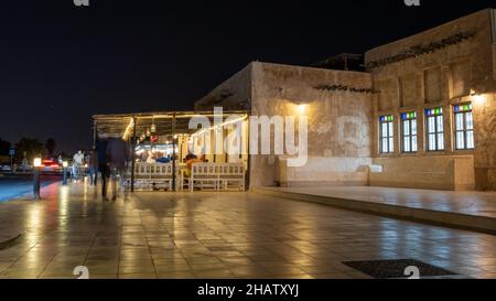 Wakrah, Qatar- Dicembre 12,2021 : la gente che gode di un tè caldo ad un ristorante a wakrah souq.shot durante la notte Foto Stock