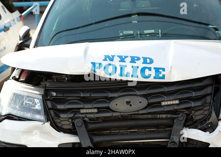 New York, NY - 2 ottobre 2021: Macchina di pattuglia NYPD schiantata con il logo della polizia su cofano ammaccato e griglia schiacciata. Foto Stock