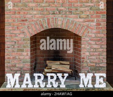 Le parole mi sposano di fronte ad un camino in mattoni Foto Stock