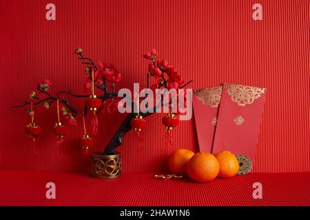 Decorazioni del festival cinese di nuovo anno. Arancione, foglia, rosso, prugna fiore su sfondo rosso. Foto Stock
